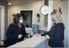 Two dental professionals using their newly remodeled front desk. 