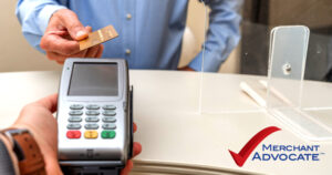 Patient paying via a credit card terminal at the front desk of a dental practice